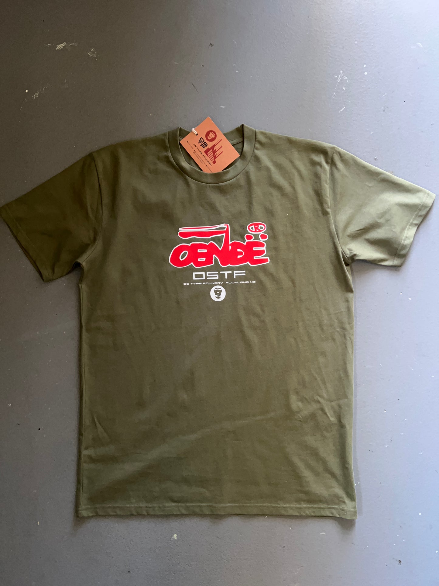 OENDE in red and white on khaki 100% cotton Tee. Can be available in medium weight 185gsm (6.5oz) and heavy weight 220gsm (7.7oz). Typeface: Union