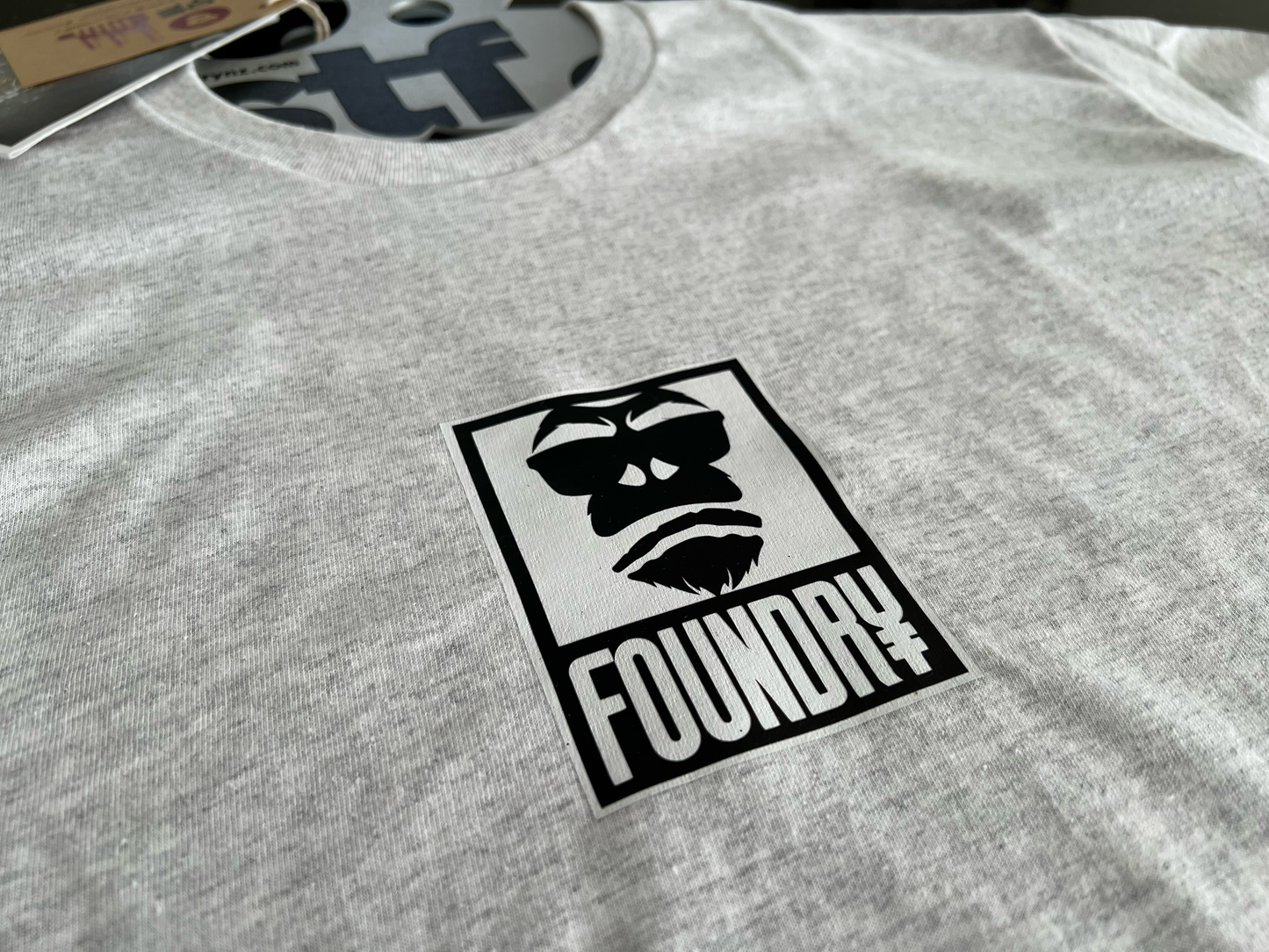 Gray t-shirt with a black and white logo featuring a gorilla face and 'Foundry' text.