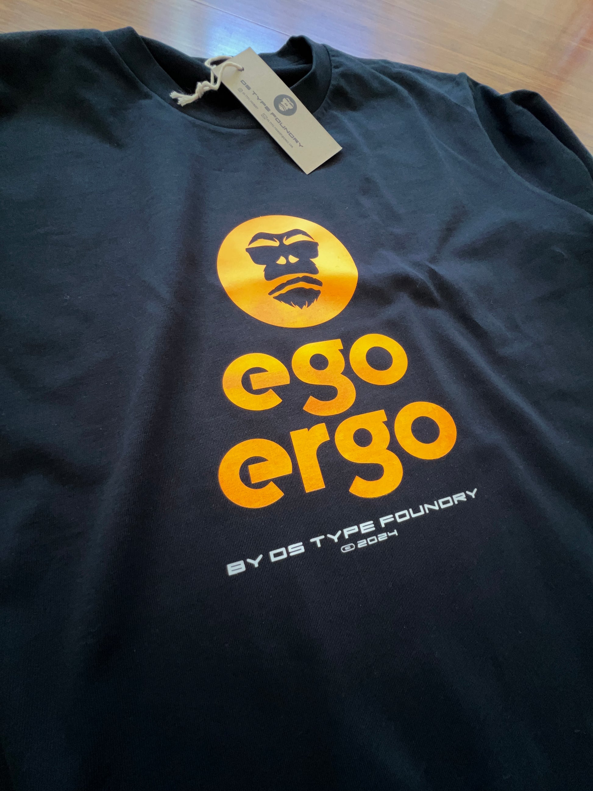 Ego Ergo in Neon Orange on dark navy blue tee, 100% cotton 220gsm. Typeface: Ego