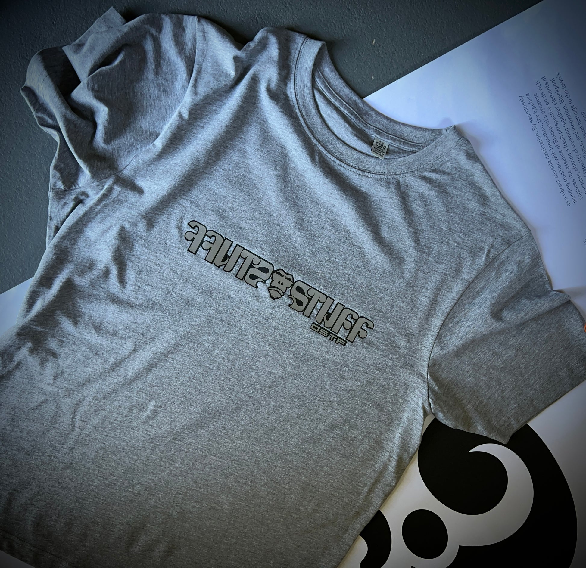 Stuff in reflective silver with black outline on grey 100% cotton Tee. Can be available in medium weight 185gsm (6.5oz) and heavy weight 220gsm (7.7oz). Typeface: Stuff
