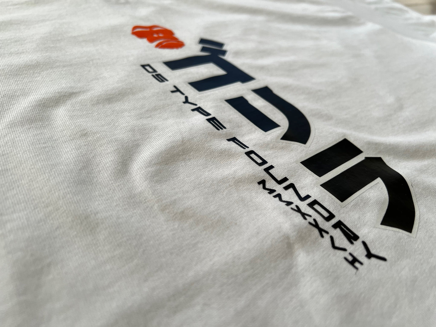 A white crewneck t-shirt  featuring a black stylized logo and the text 'DS TYPE FOUNDRY MMXXVI' printed on the chest.