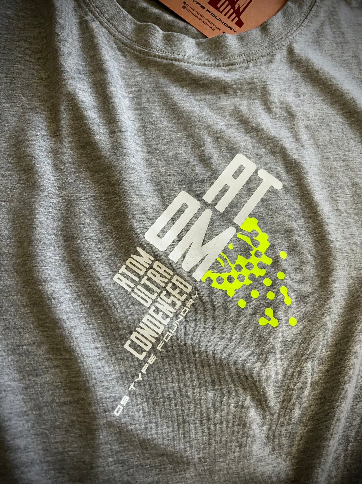Atom in White and neon yellow on grey, 100% cotton Tee.