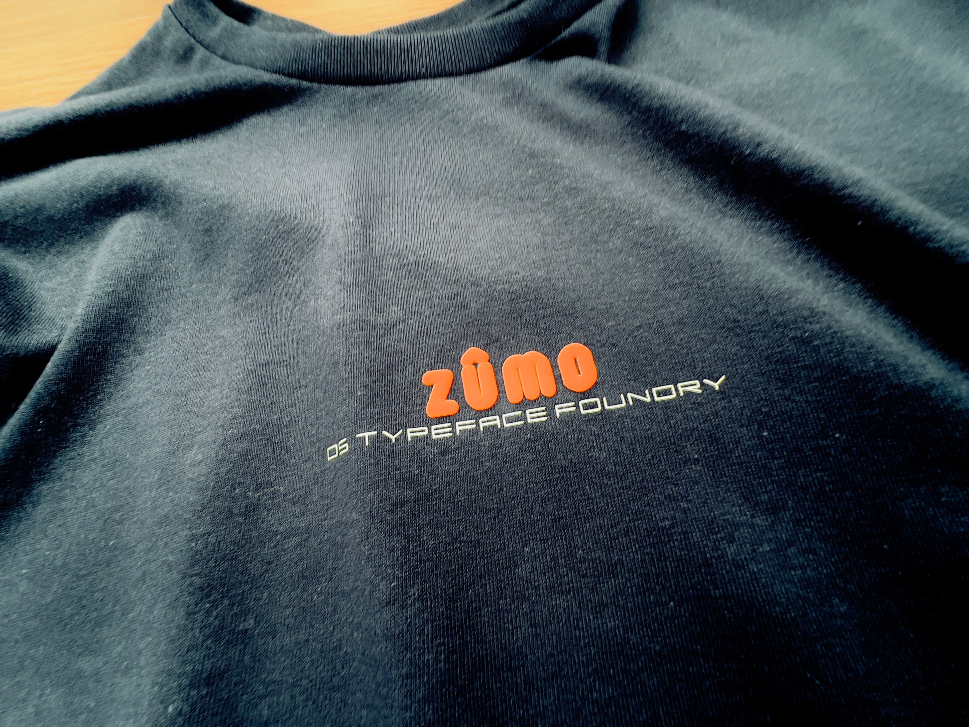 Zumo Puff Orange on Black tee.  100% cotton. Typeface: Zumo