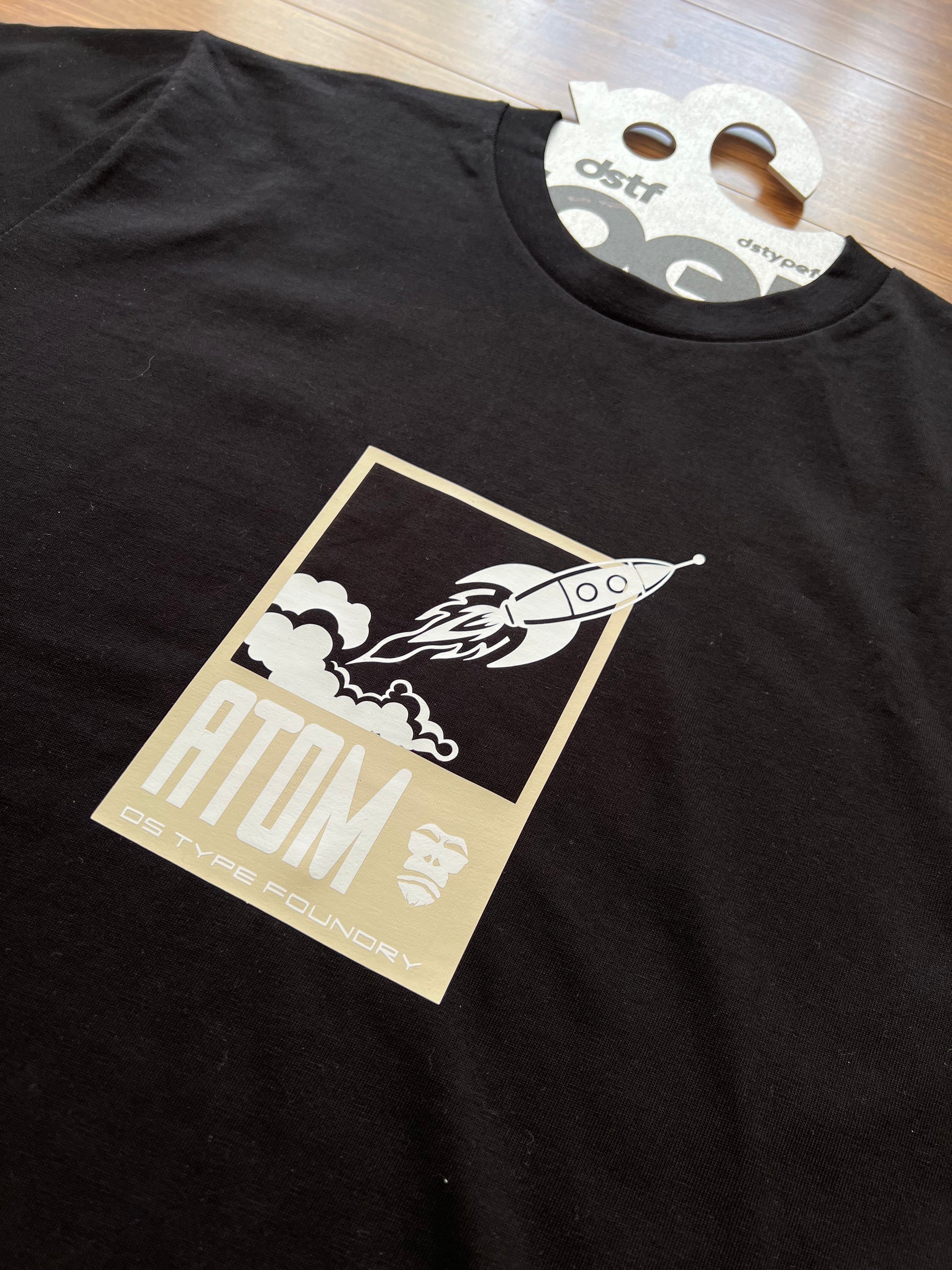 retro rocket on Black t-shirt with a graphic design and a visible brand tag
